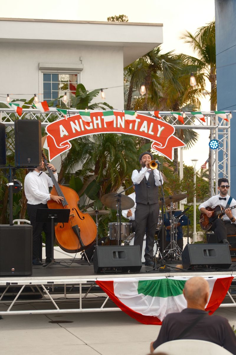 Band performing on the stage under the A Night in Italy banner